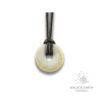 Natural 30mm agate donut pendant hanging from a black vegan cord.