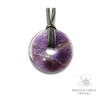 Natural 40mm amethyst donut pendant hanging from a black vegan cord.