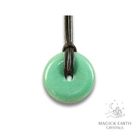 Natural 40mm aventurine donut pendant hanging from a black vegan cord.