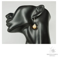 Beige Electroplated Druzy Geode and Obsidian Earrings With Platinum Finish on Display Head