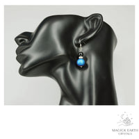 Blue Electroplated Druzy Geode and Obsidian Earrings With Platinum Finish on display head
