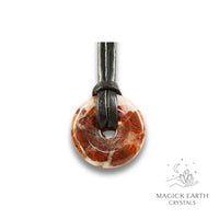 Natural 30mm brecciated jasper donut pendant hanging from a black vegan cord.