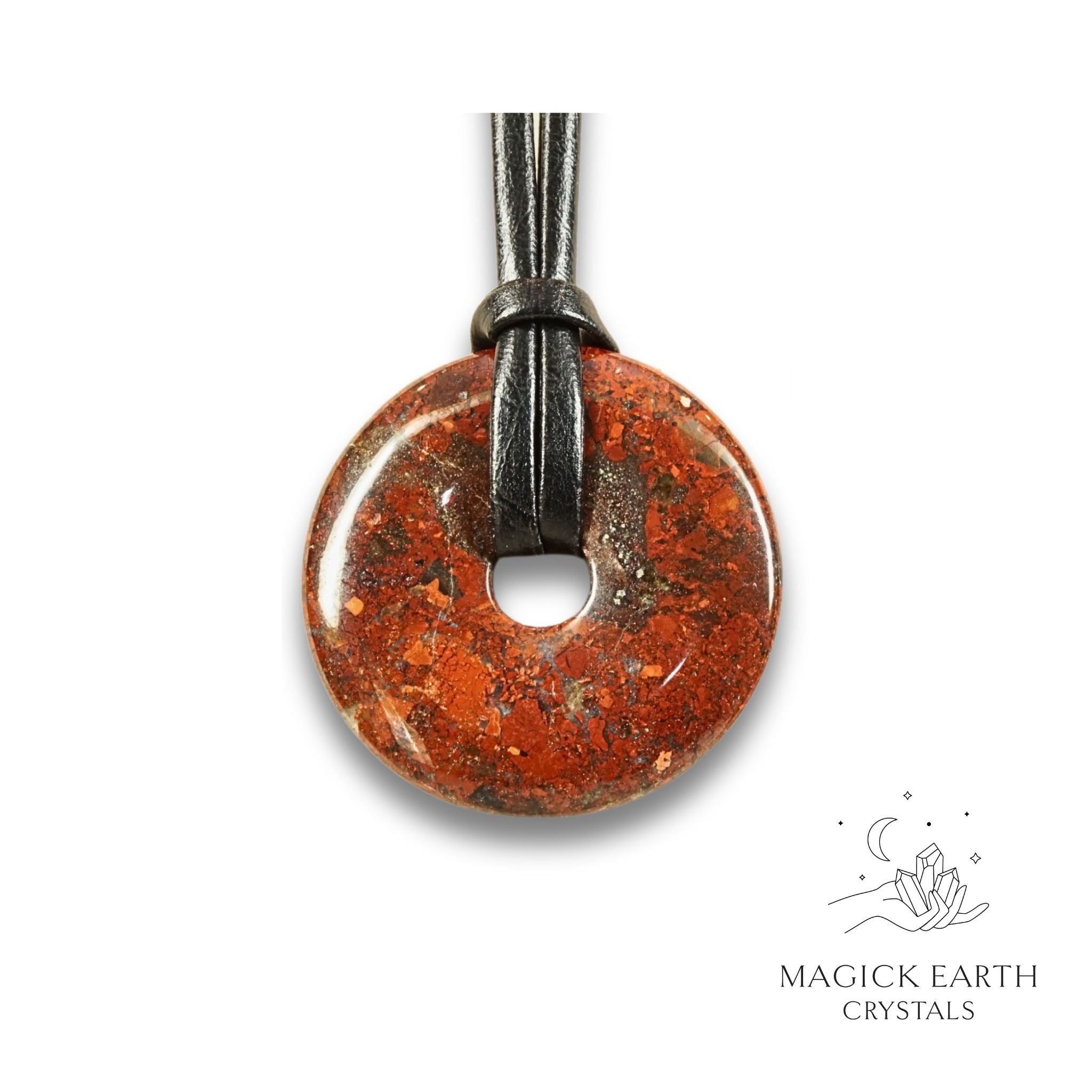 Natural 40mm brecciated jasper donut pendant hanging from a black vegan cord.