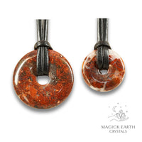 Natural brecciated jasper donut pendants in two sizes hanging from black vegan cords arranged left to right from large to small