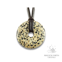 Natural 50mm Dalmatian jasper donut pendant hanging from a black vegan cord.