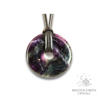 Natural 50mm dark fluorite donut pendant hanging from a black vegan cord.