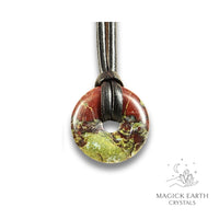 Natural 30mm dragons blood jasper donut pendant hanging from a black vegan cord.