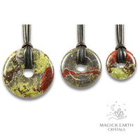 Natural dragons blood jasper donut pendants in three sizes hanging from black vegan cords arranged left to right from large to small