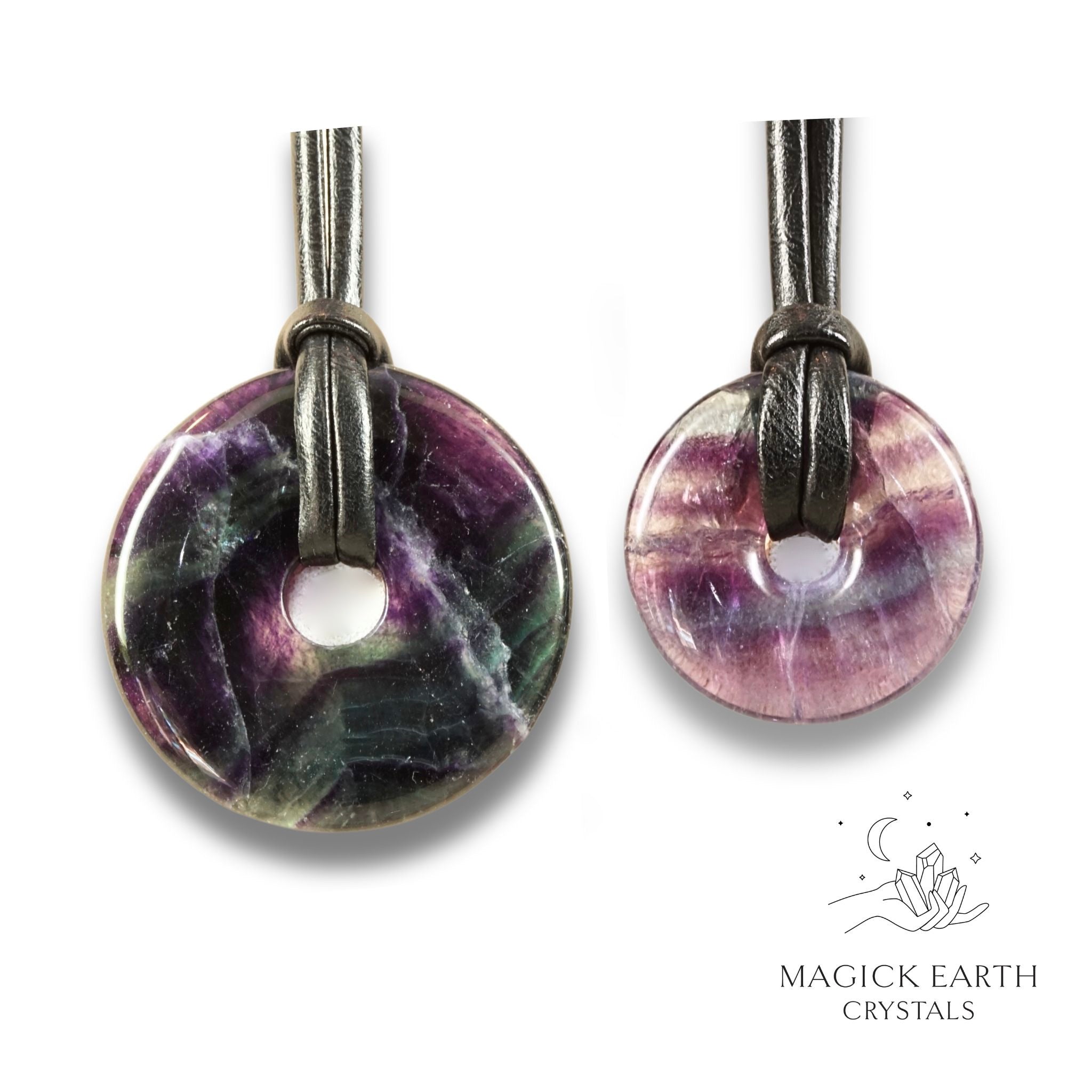 Natural dark fluorite donut pendants in two sizes hanging from black vegan cords arranged left to right from large to small
