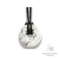 Natural 30mm howlite donut pendant hanging from a black vegan cord.