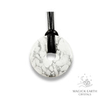 Natural 40mm howlite donut pendant hanging from a black vegan cord.