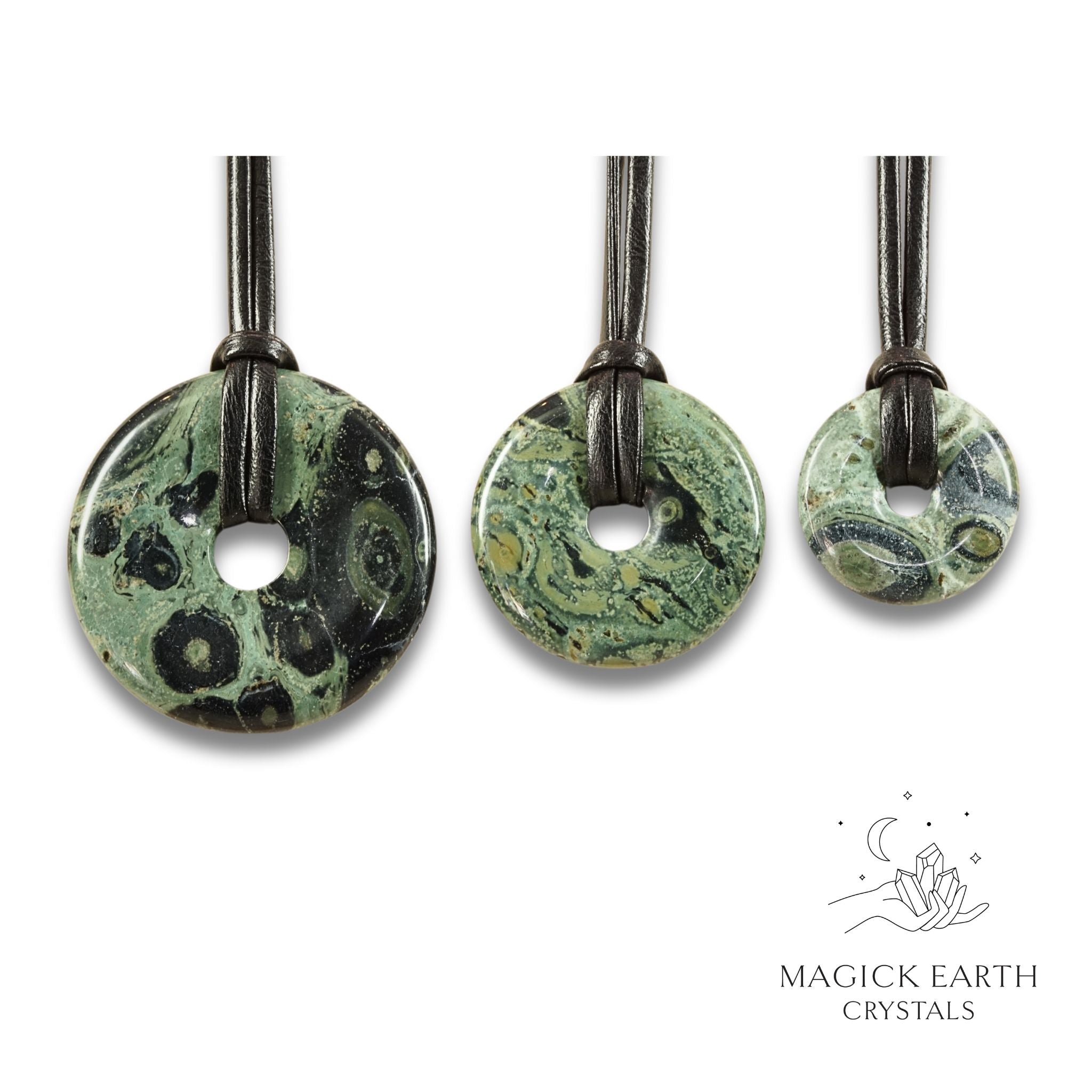 Natural kambaba jasper donut pendants in three sizes hanging from black vegan cords arranged left to right from large to small