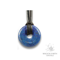 Natural 30mm lapis lazuli donut pendant hanging from a black vegan cord.