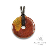 Natural 50mm mookaite jasper donut pendant hanging from a black vegan cord.