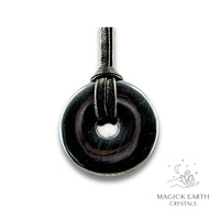 Natural 30mm obsidian donut pendant hanging from a black vegan cord.