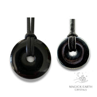 Natural obsidian donut pendants in two sizes hanging from black vegan cords arranged left to right from large to small