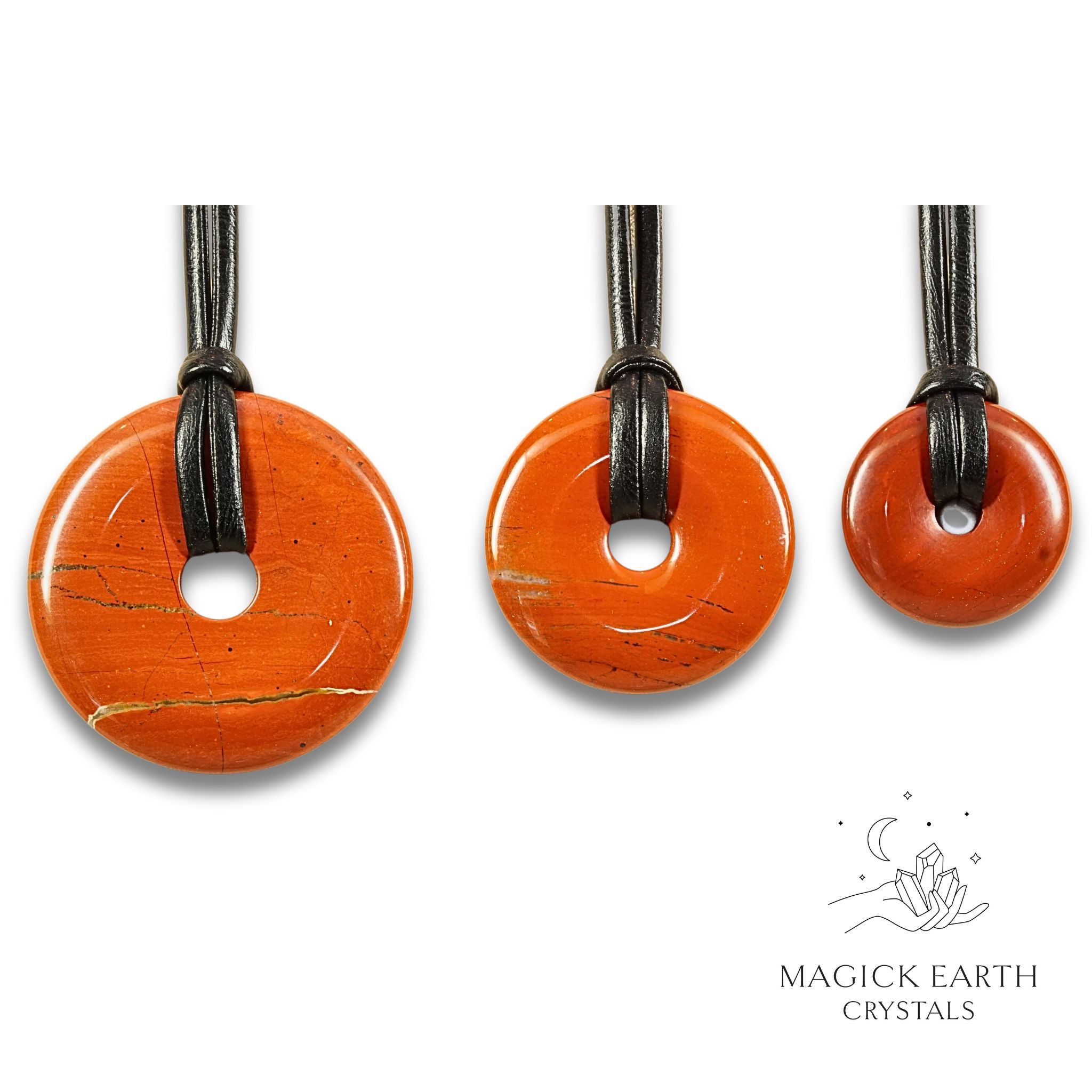 Natural red jasper donut pendants in three sizes hanging from black vegan cords arranged left to right from large to small