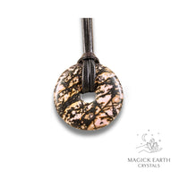 Natural 40mm rhodonite donut pendant hanging from a black vegan cord.