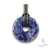 Natural 50mm sodalite donut pendant hanging from a black vegan cord.