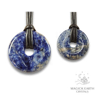 Natural sodalite donut pendants in two sizes hanging from black vegan cords arranged left to right from large to small