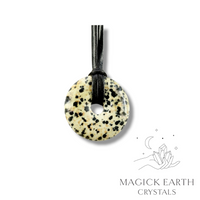 Natural 40mm Dalmatian jasper donut pendant hanging from a black vegan cord.